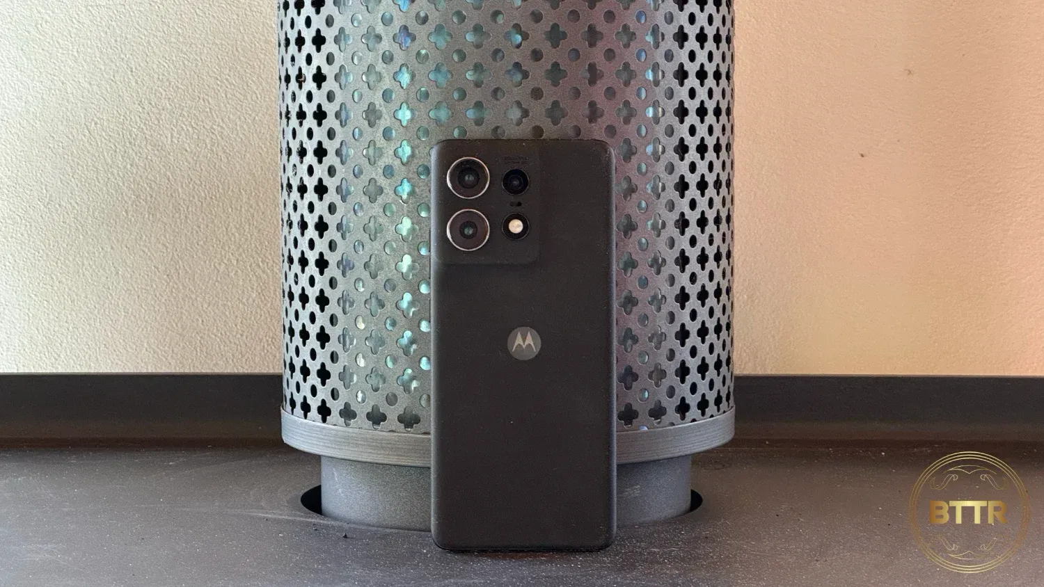 The back of the Moto Edge 50 Pro, as it stands against a fireplace chimney