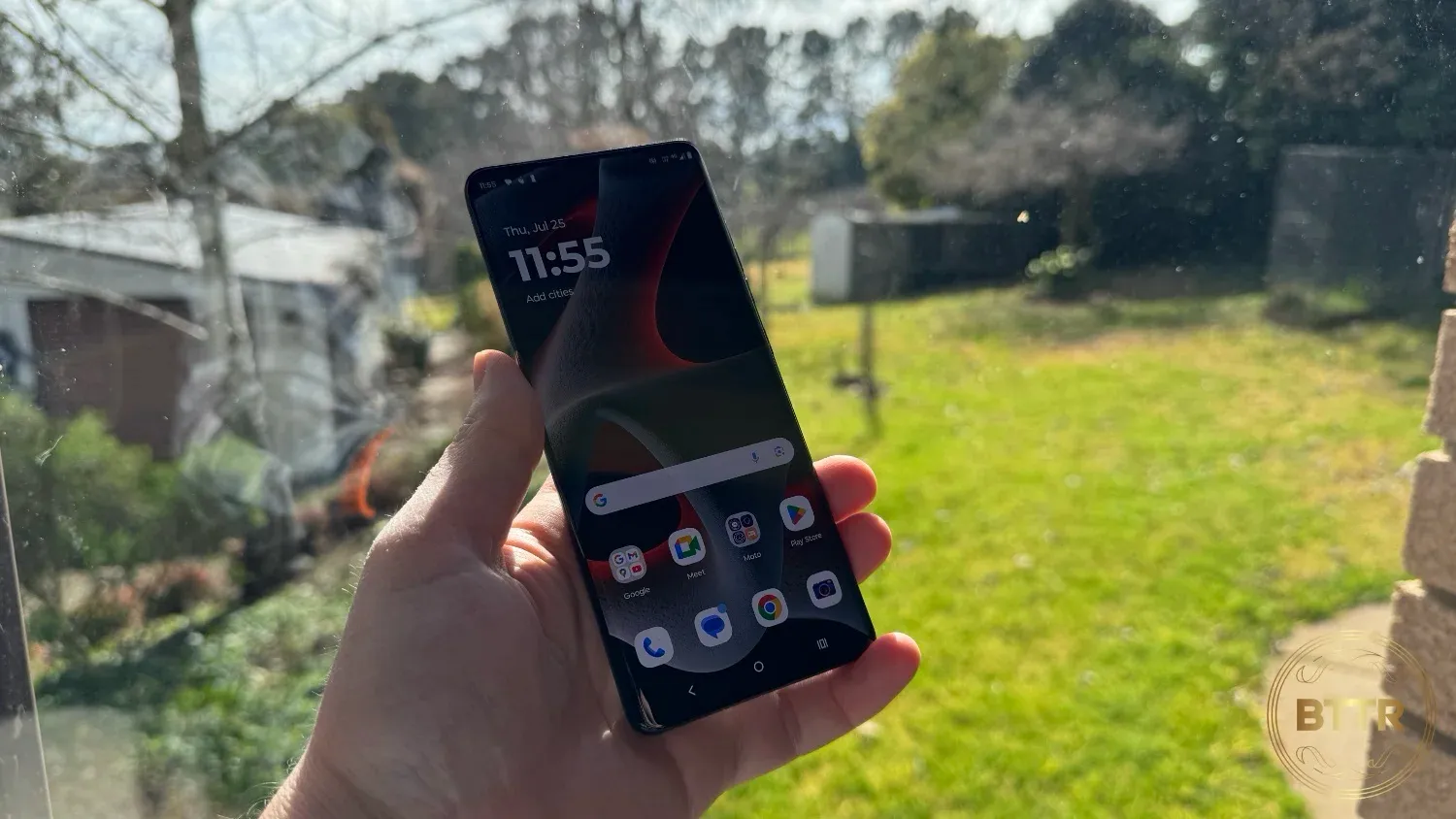 Holding up the Moto Edge 50 Pro in front of a garden view