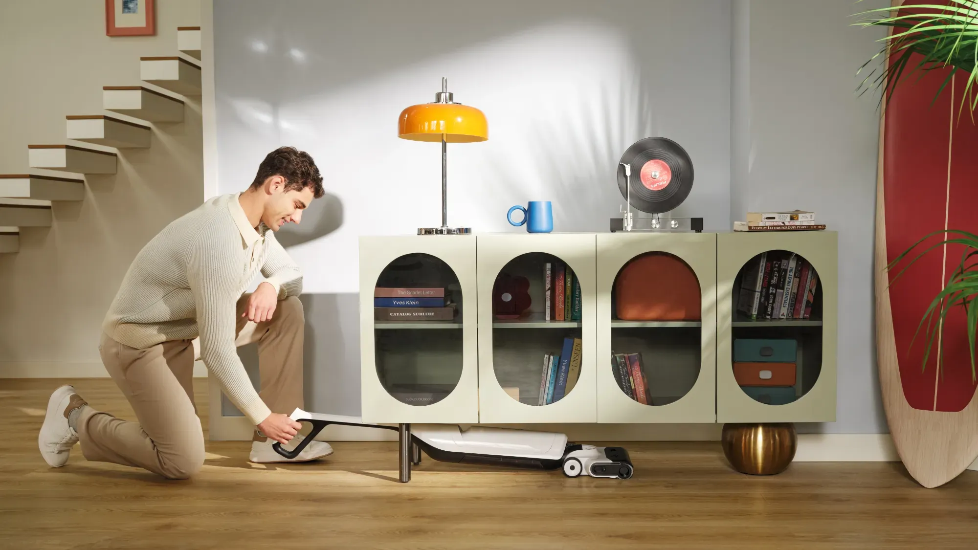 Man using the Roborock Flexi Lite under a storage cupboard