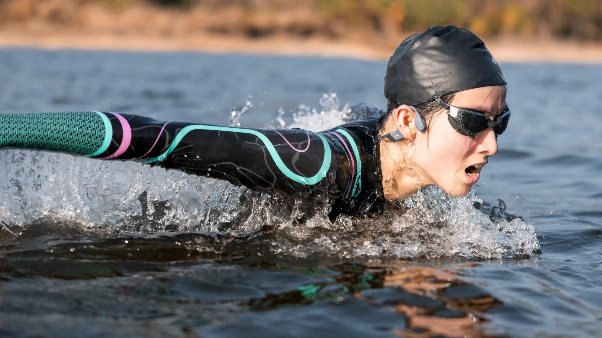 A woman swimming while wearing the OpenSwim Pro