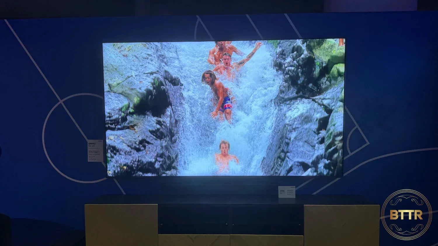 An 8K Neo QLED panel showing people sliding down a waterfall.