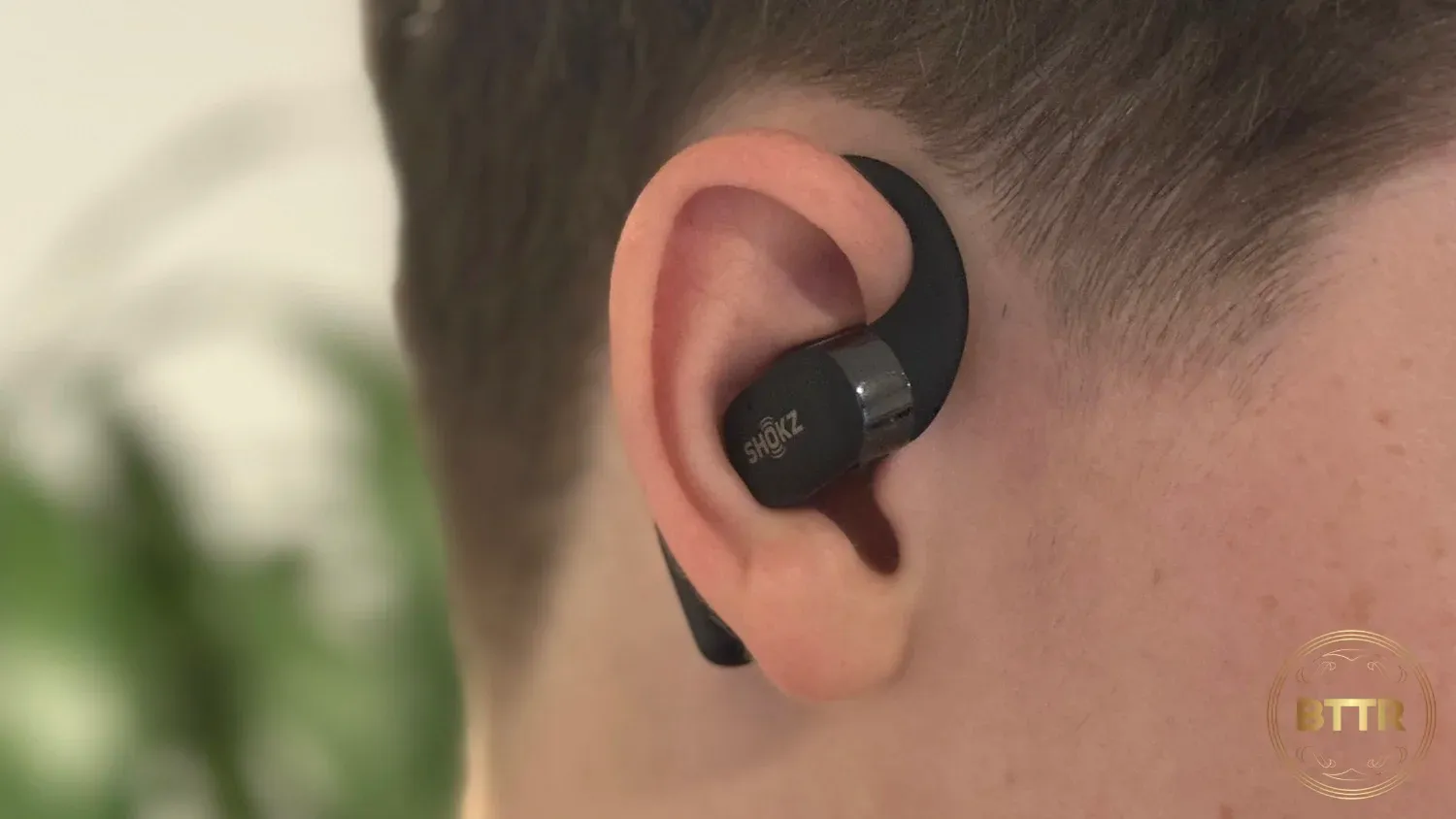 The right Shokz Openfit being viewed in-ear from the front