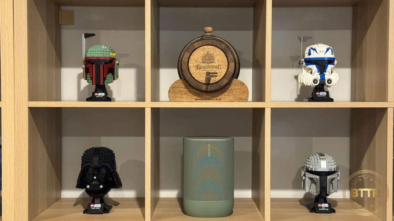 The Sonos Move 2 speaker on an Ikea's Kallax shelf with Lego Star Wars Helmets and a whiskey barrel