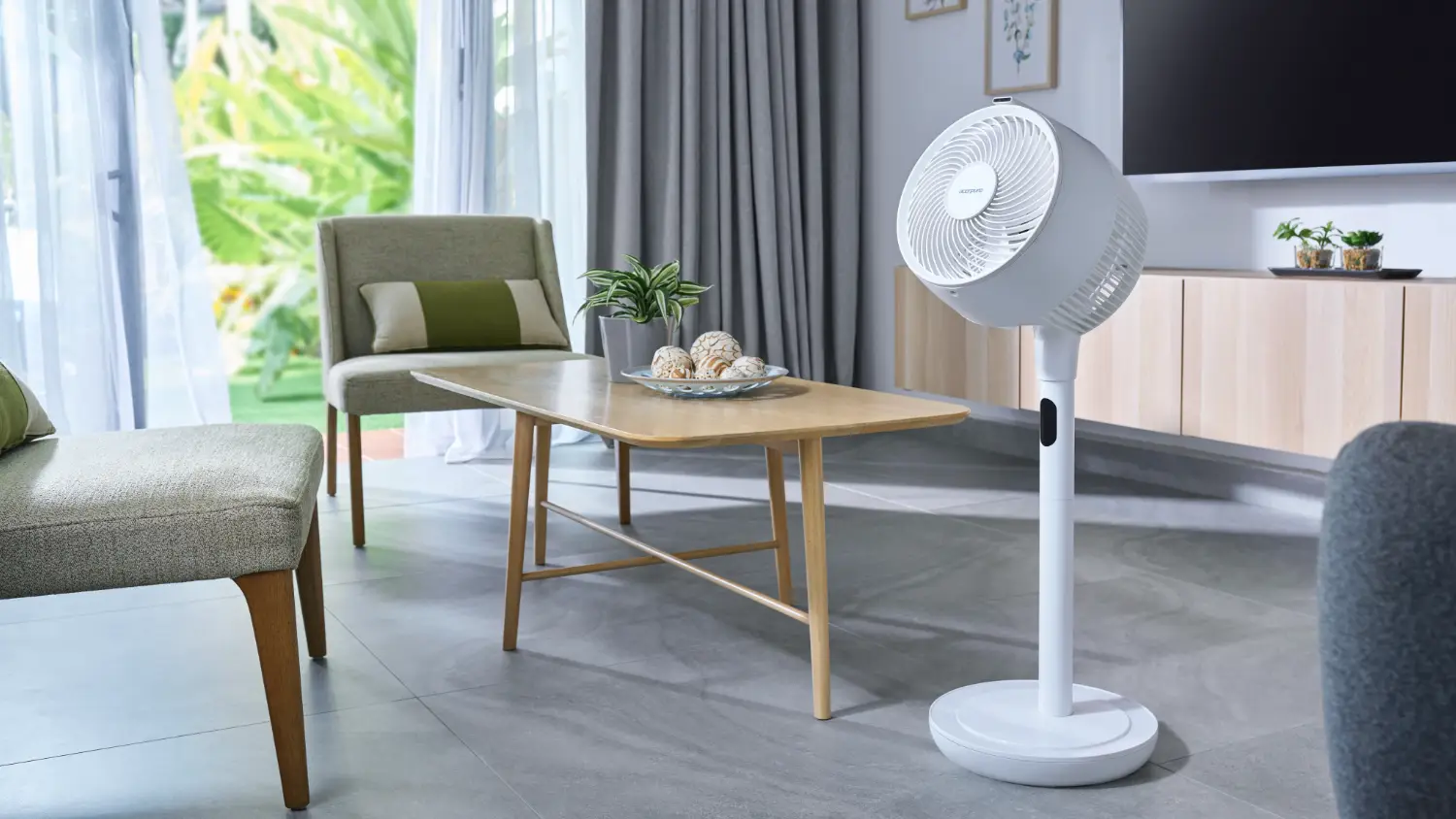 The Acerpure cozy pedestal fan next to a coffee table in pedestal mode