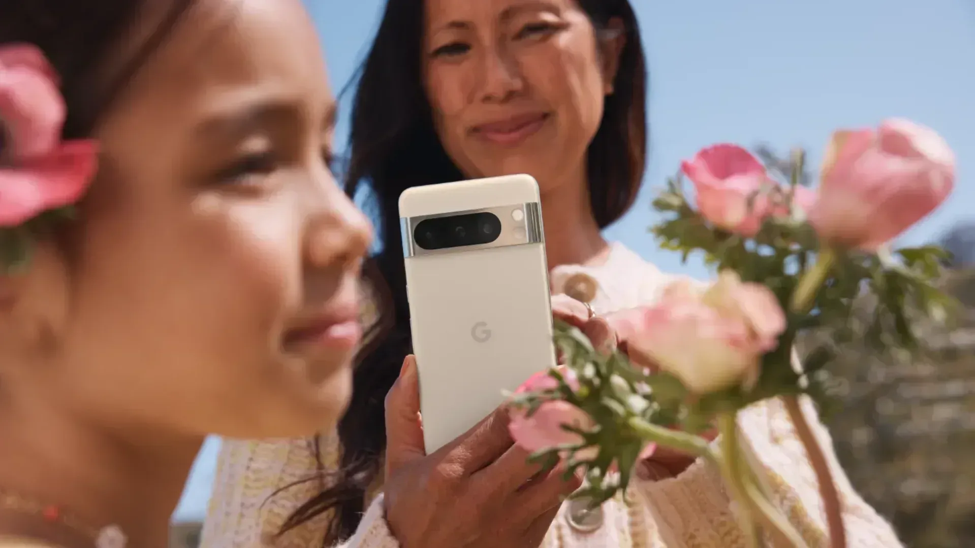 A woman taking a photo of her daughter with the Pixel 8 Pro