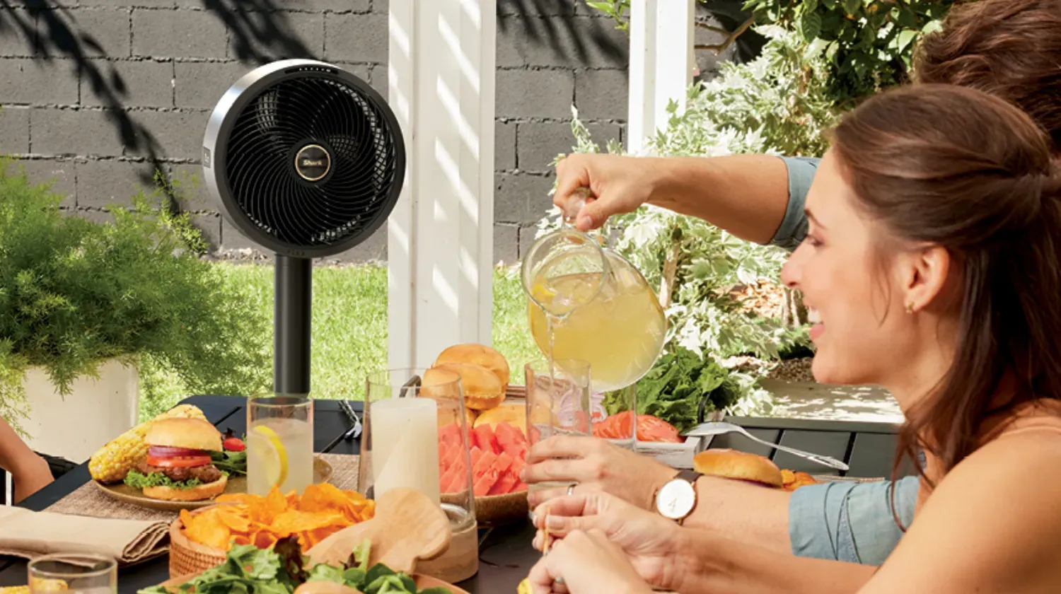 The FlexBreeze Fan on a table outside while people have lunch