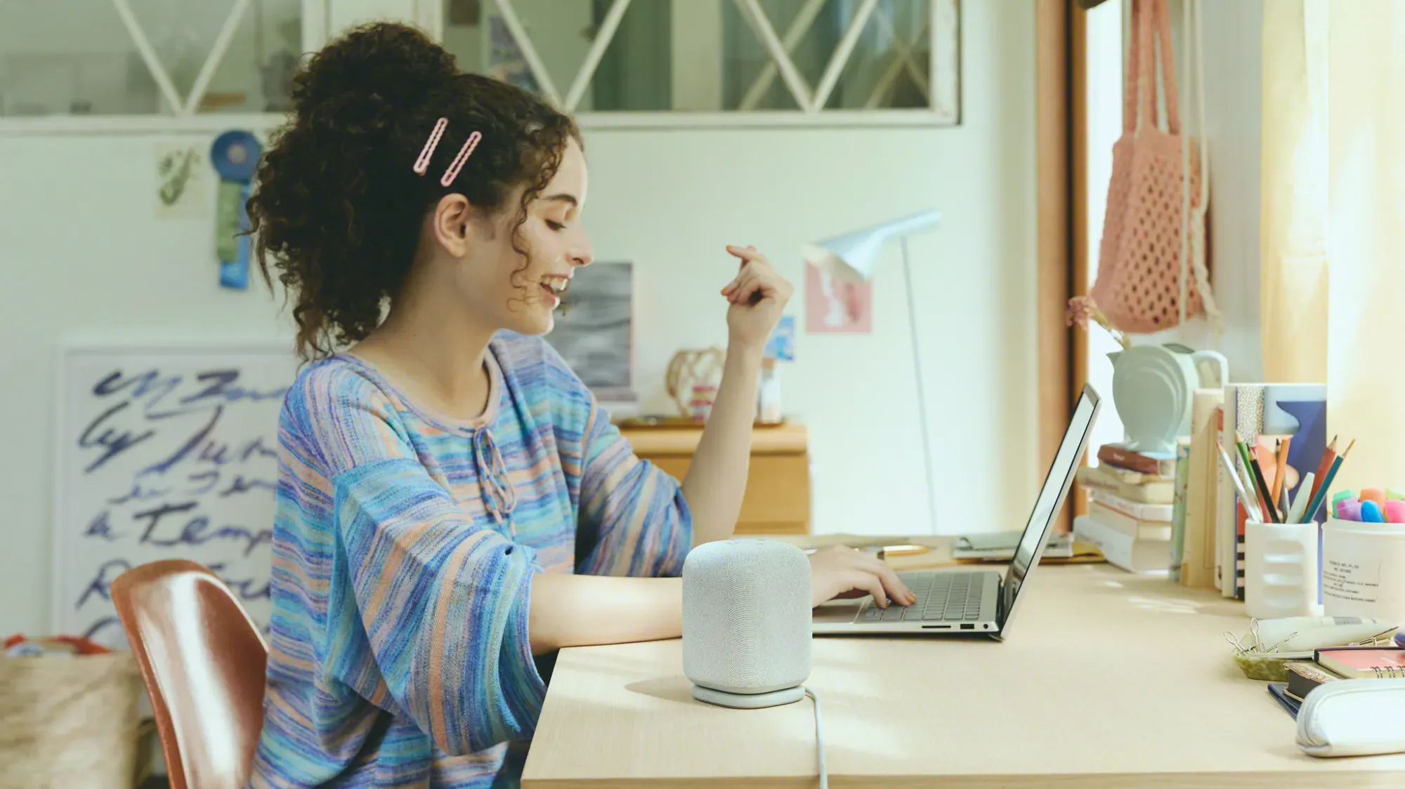 A woman working on a laptop next to the LinkBuds Speaker