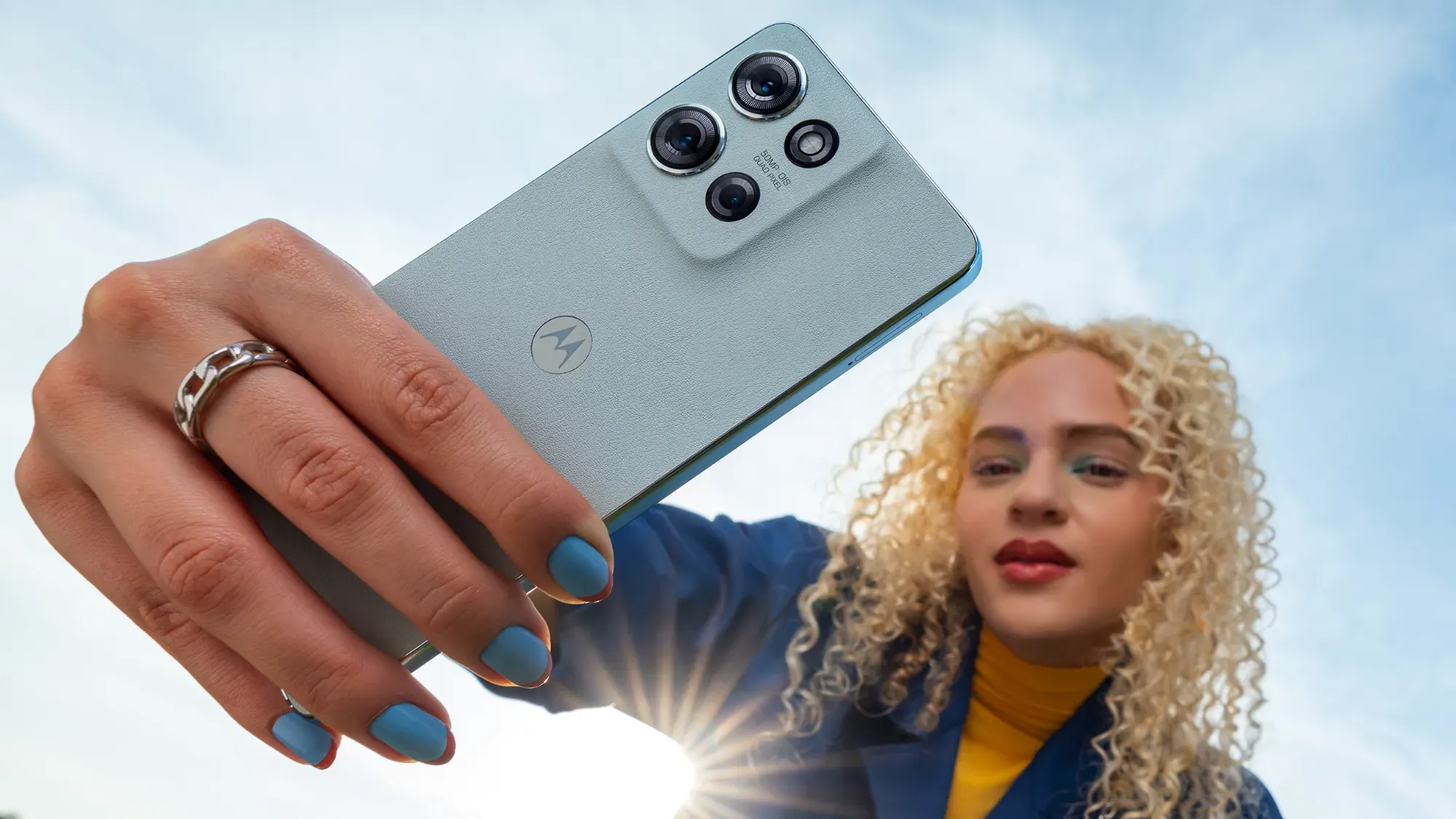 A woman with curly blonde hair holding the G75 in front of her