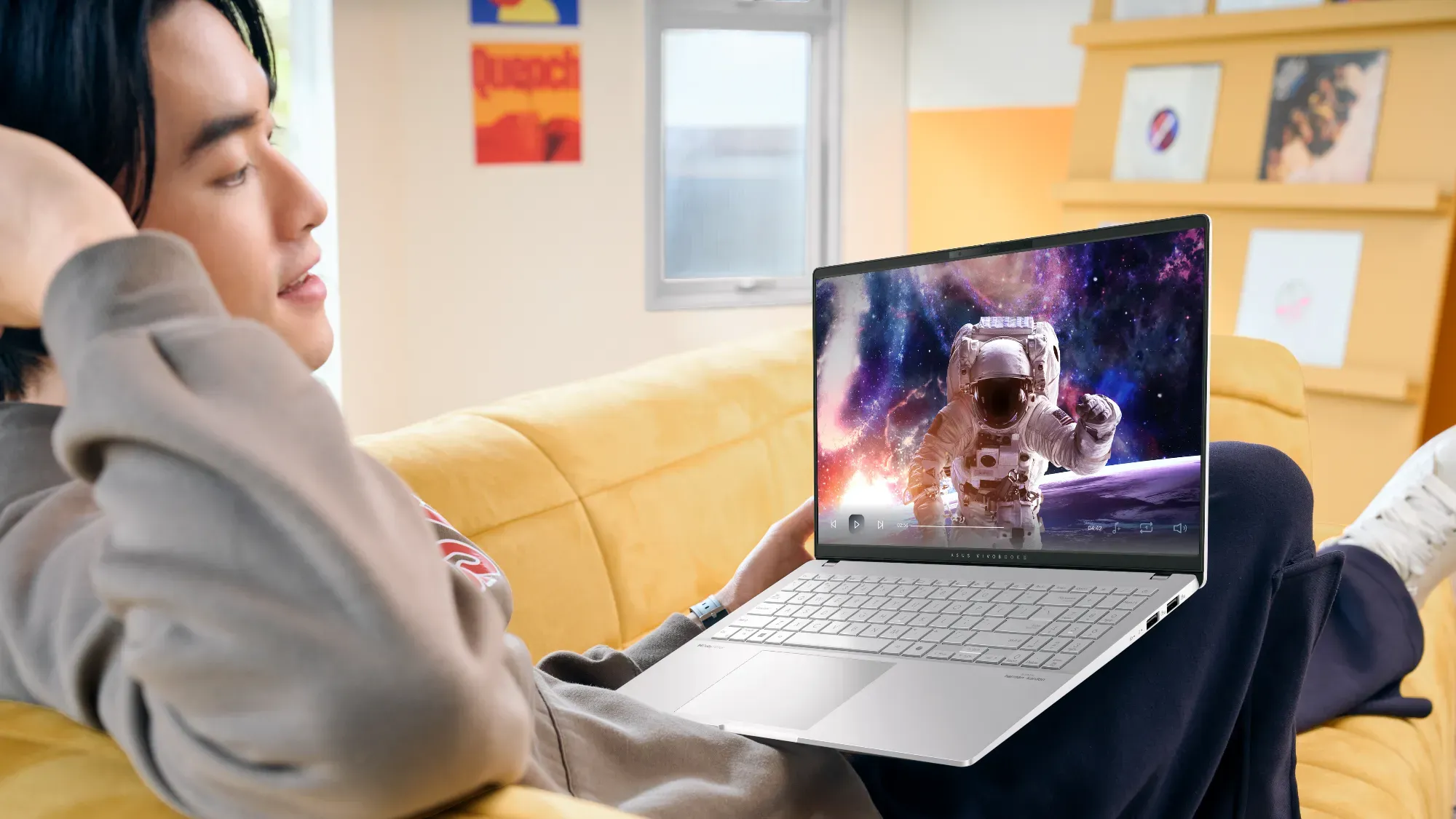 A man lounging on the couch looking at the new ASUS CoPilot+ Vivobook S