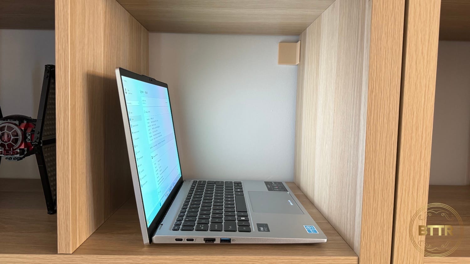 The Acer Swift Go in a bookshelf