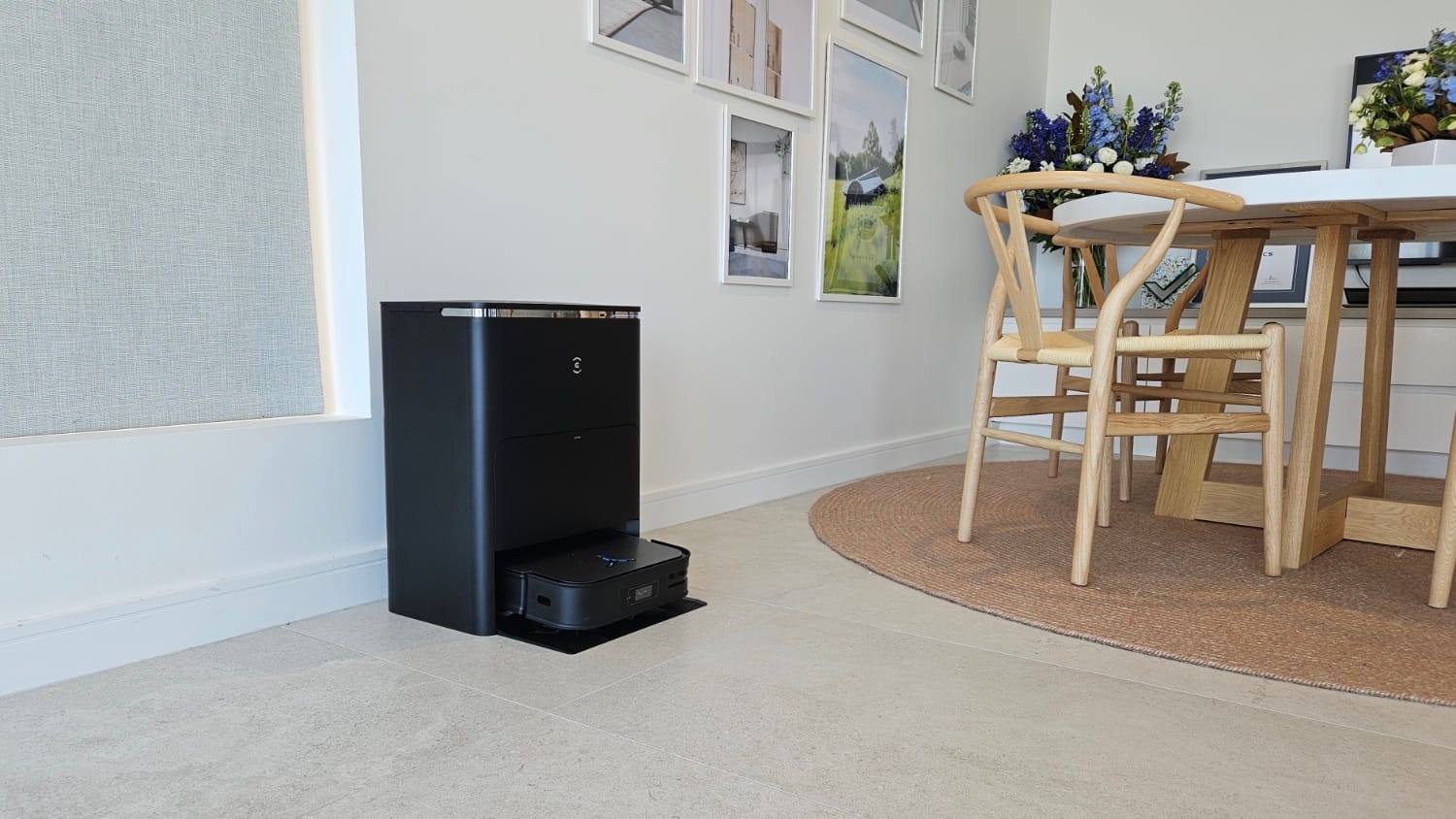 The Ecovacs Deebot X2 Omni in its charger in a room with a table and chairs