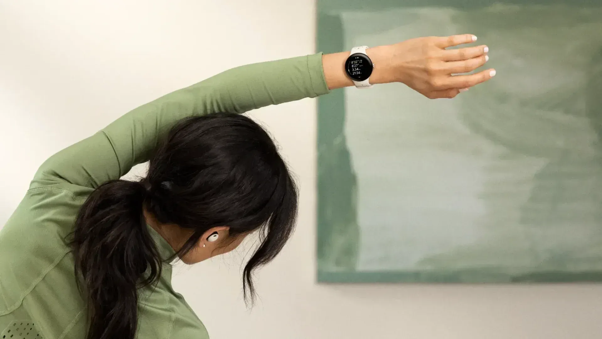 Woman stretching while wearing the pixel watch 2 and pixel buds pro