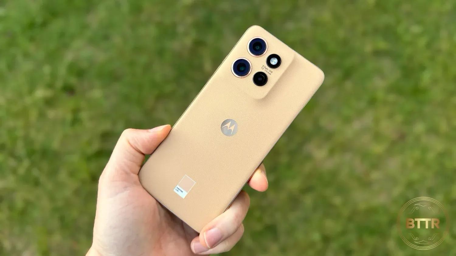 The Moto Edge 50 Neo in hand over grass