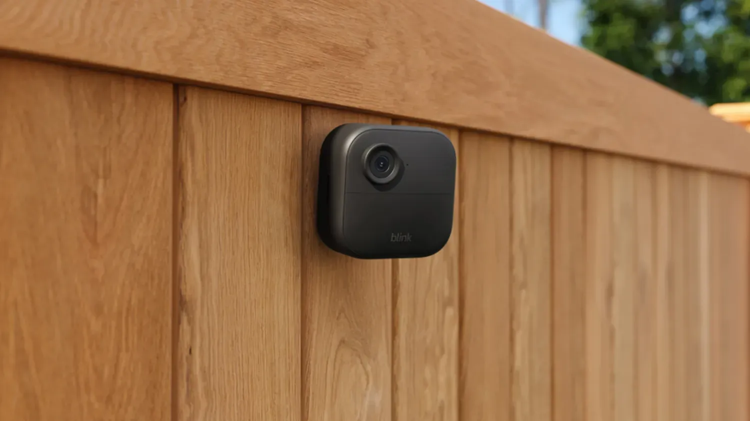 The Blink outdoor camera on a wooden fence