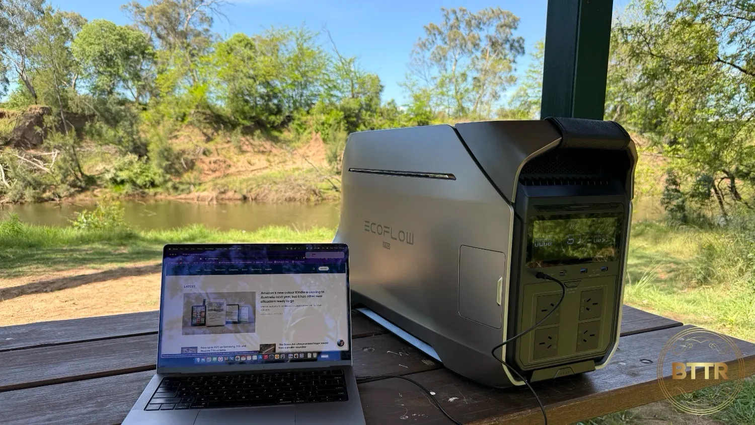 The Delta Pro 3 charging a MacBook Pro 14 by a river