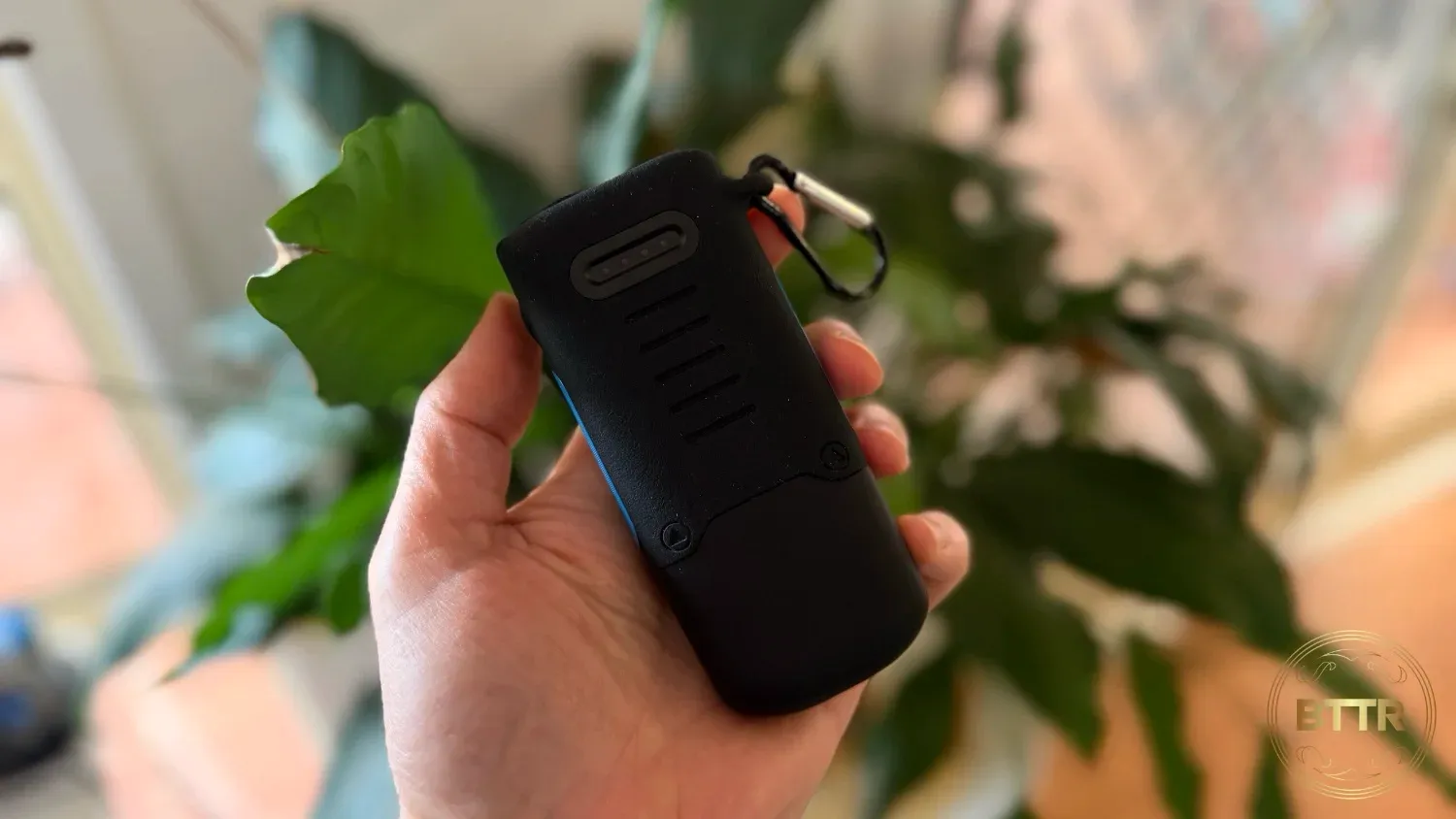 Holding the NRGVault power bank by a plant