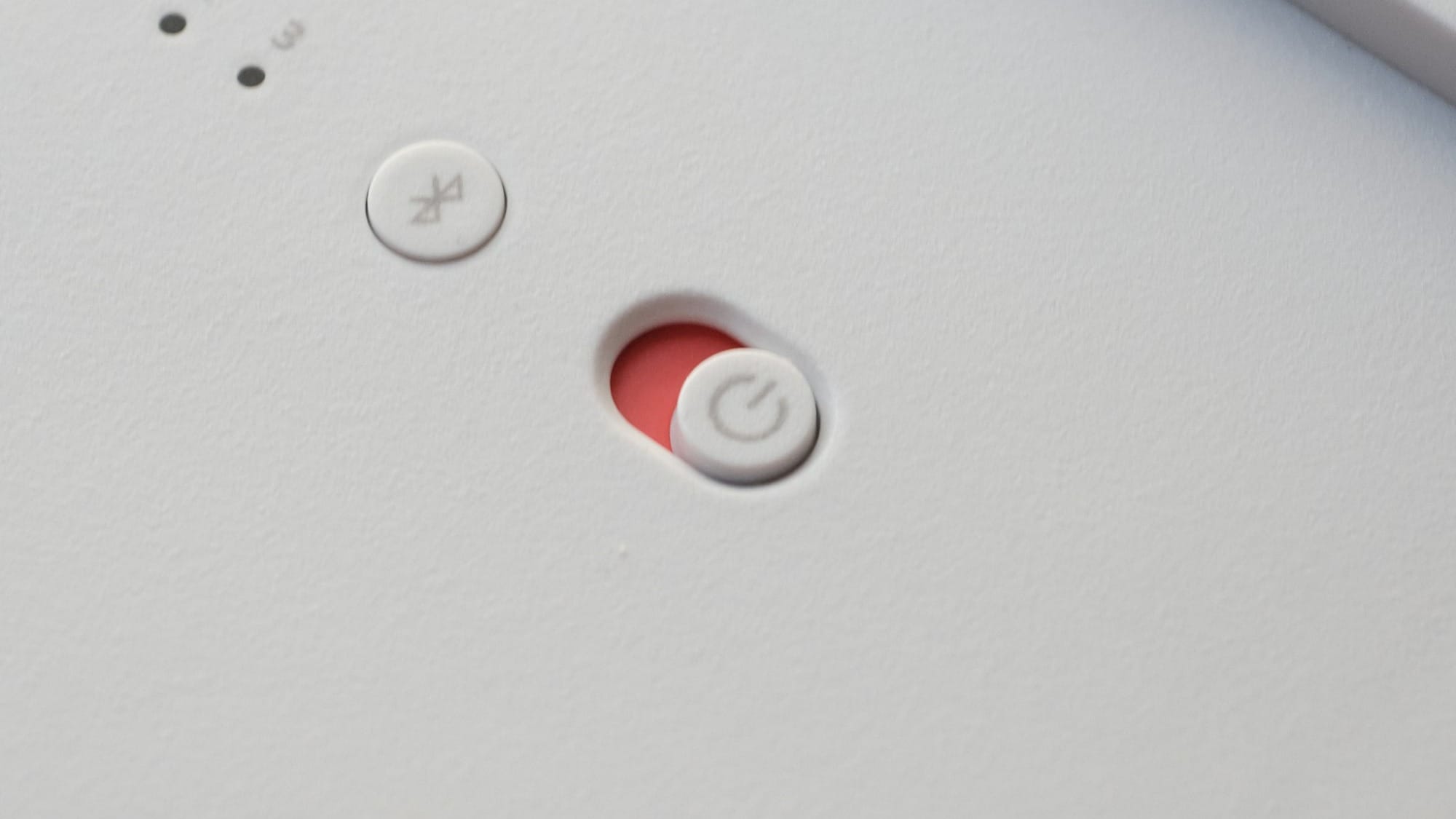 A power switch on a gadget next to a Bluetooth button.