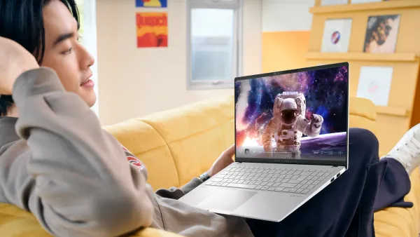 A man lounging on the couch looking at the new ASUS CoPilot+ Vivobook S