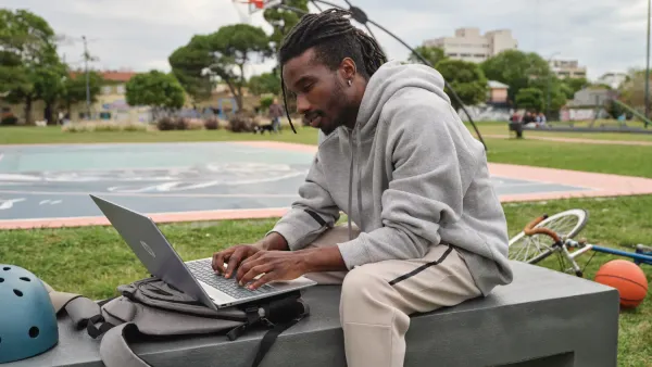 A man in a park using an HP Pavilion laptop