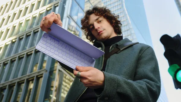 A man holding the purple Logitech Keys