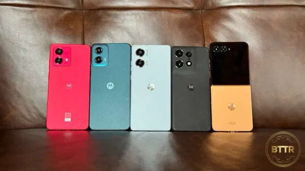 Five Motorola devices lined up on a brown leather couch side by side