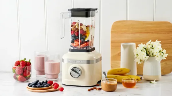 A blender in a kitchen surrounded by colourful ingredients