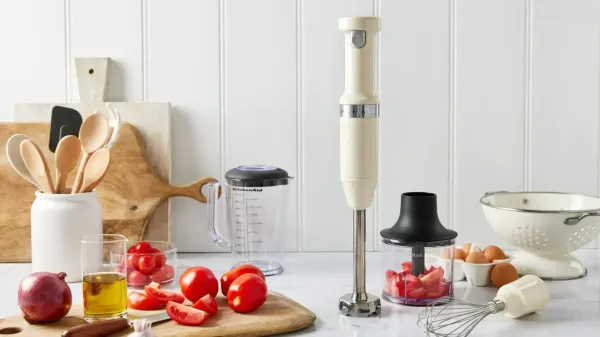 A stick blender on a kitchen benchtop surrounded by food and cooking equipment