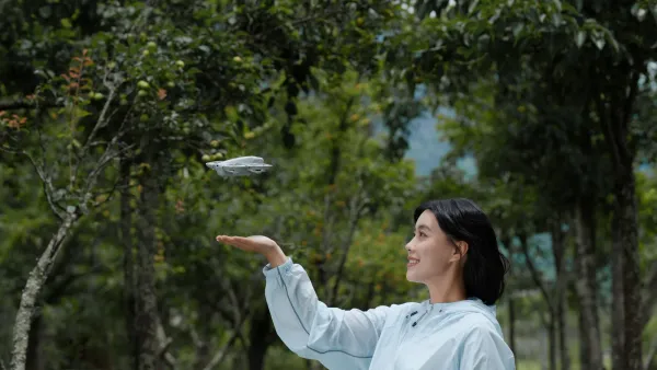 A woman holding out her hand for the DJI Neo to land on