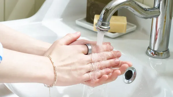 A pair of hands washing under a faucet while wearing a Galaxy Ring.