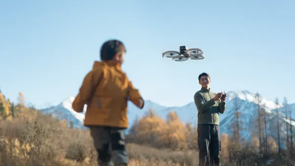 A man flying the DJI flip with a child in the foreground