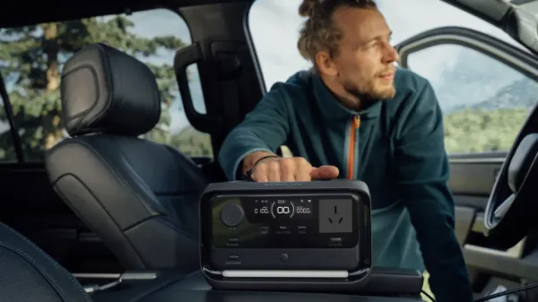 A man with a beardholding the new Ecoflow River 3 Plus in a car