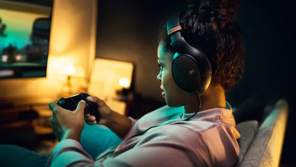 A woman playing video games while wearing the Sennheiser HD 505 headphones.