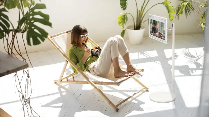 Woman on an outdoor lounge watching the LG StanbyME