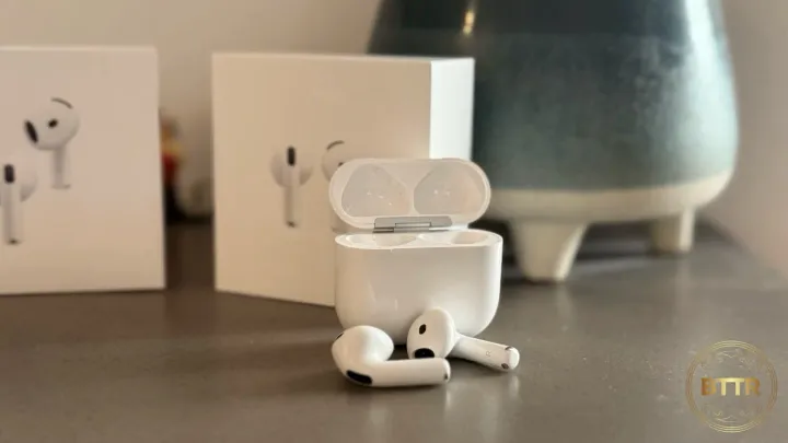 The Apple AirPods 4 with ANC in front of the box and a pot plant