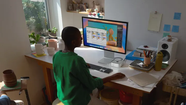 A woman working on an M4 Mac Mini in a home office